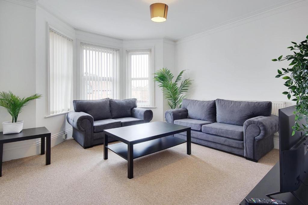 a living room with two couches and a coffee table at Ashley Road Apartment 3 in Poole