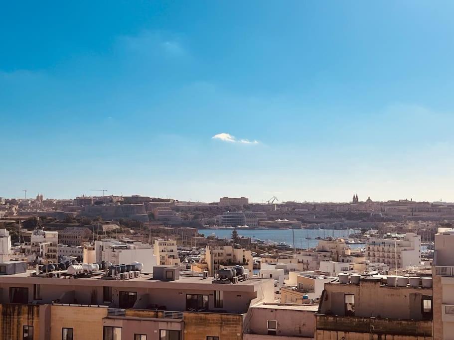 an airplane is flying in the sky over a city at Central Sliema 3bdr. Apartment in Sliema