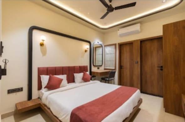 a bedroom with a large bed and a desk at Vaibhavya Hotel & Restaurant udaipur in Udaipur