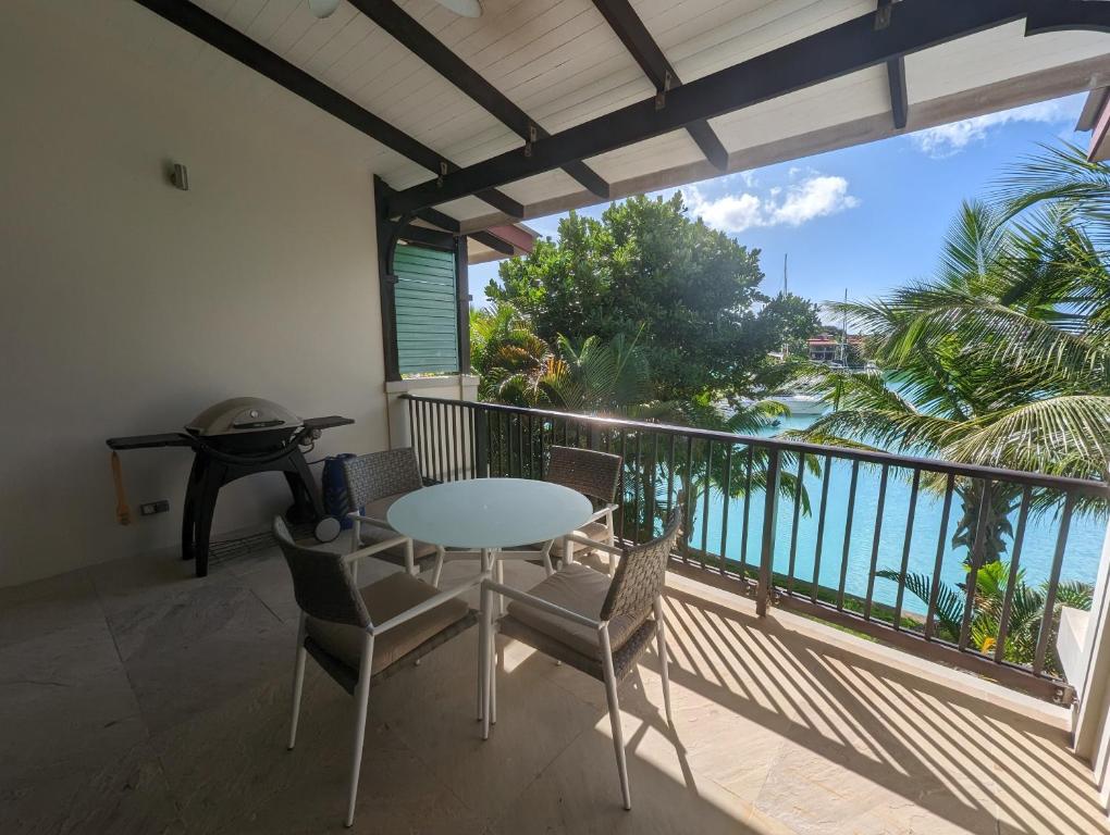 balkon ze stołem i krzesłami oraz widokiem na ocean w obiekcie Island View Apartment by Simply-Seychelles w mieście Eden Island