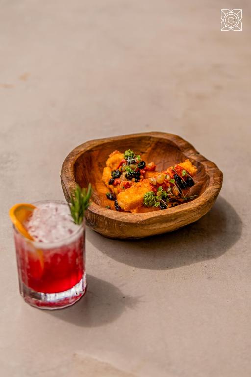a bowl of food next to a drink on a table at Zuri Zanzibar in Kendwa
