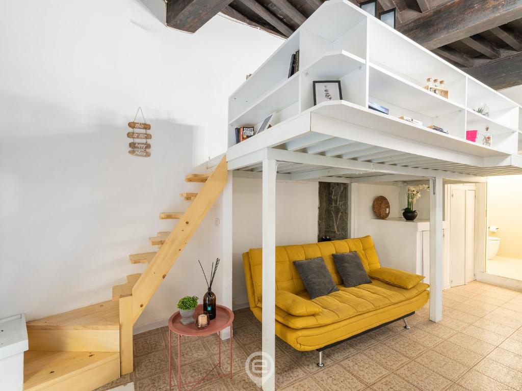 ein Wohnzimmer mit einem gelben Sofa und einem Loft in der Unterkunft Domus Cordis in Old Town in Cagliari