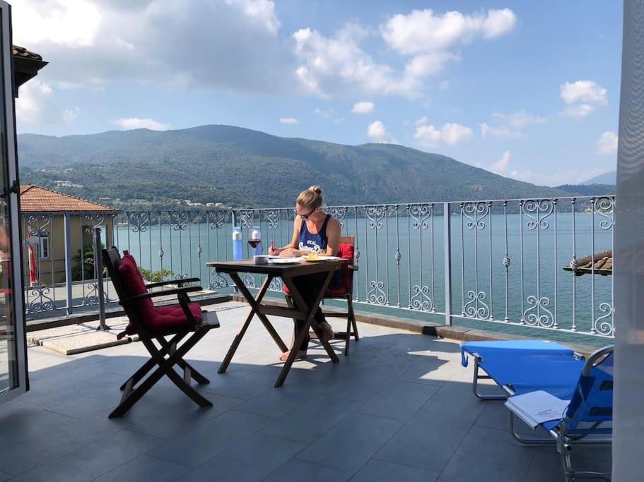 een vrouw aan een tafel op een balkon bij Lago di Lugano, riante complete vakantiewoning in Brusino Arsizio