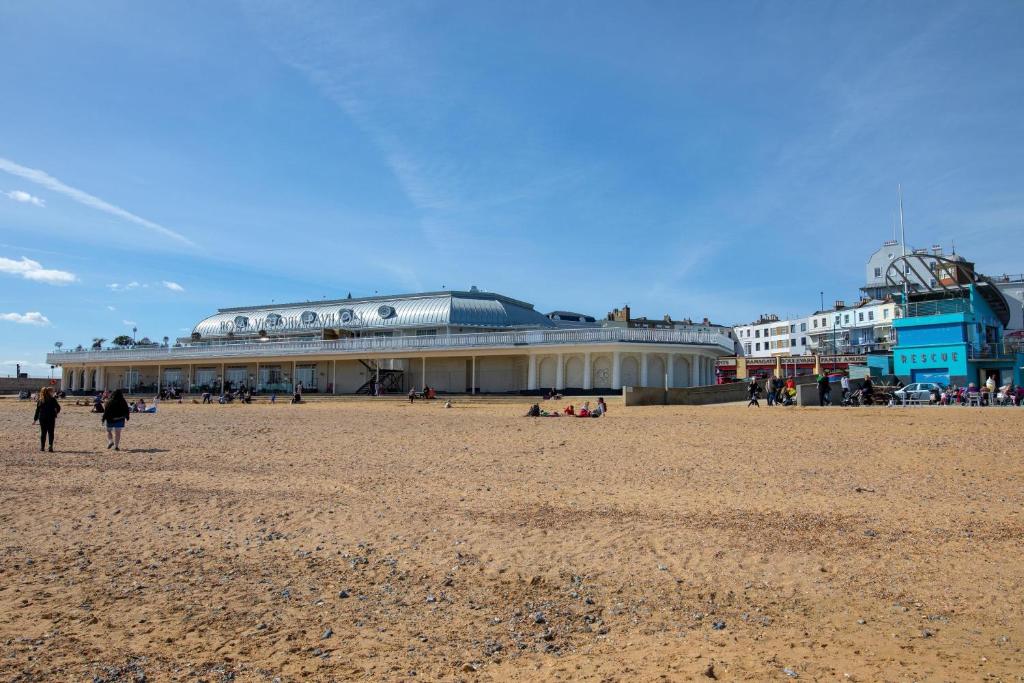 a building on the beach with people on the beach at Ramsgate room in Kent