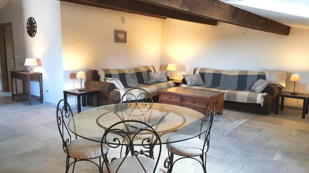 a living room with a table and chairs and a couch at 'Au Coeur des Vignes' - private apartment & garden in Magalas