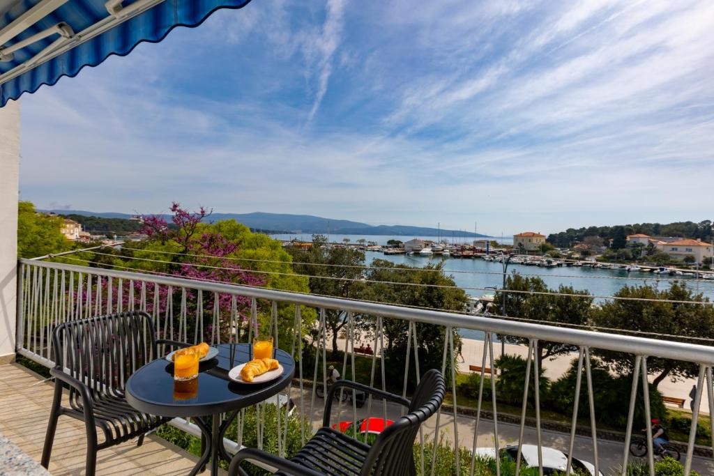 a balcony with a table and chairs and a view of the water at Apartment Marin Krk in Krk