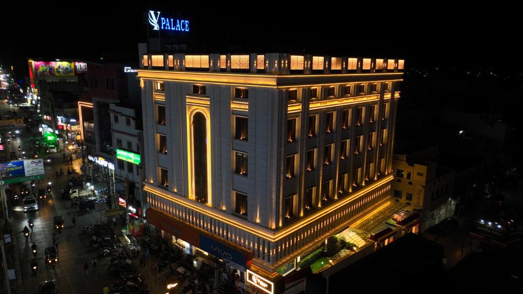 a lit up building on a city street at night at Hotel Y Palace in Ongole