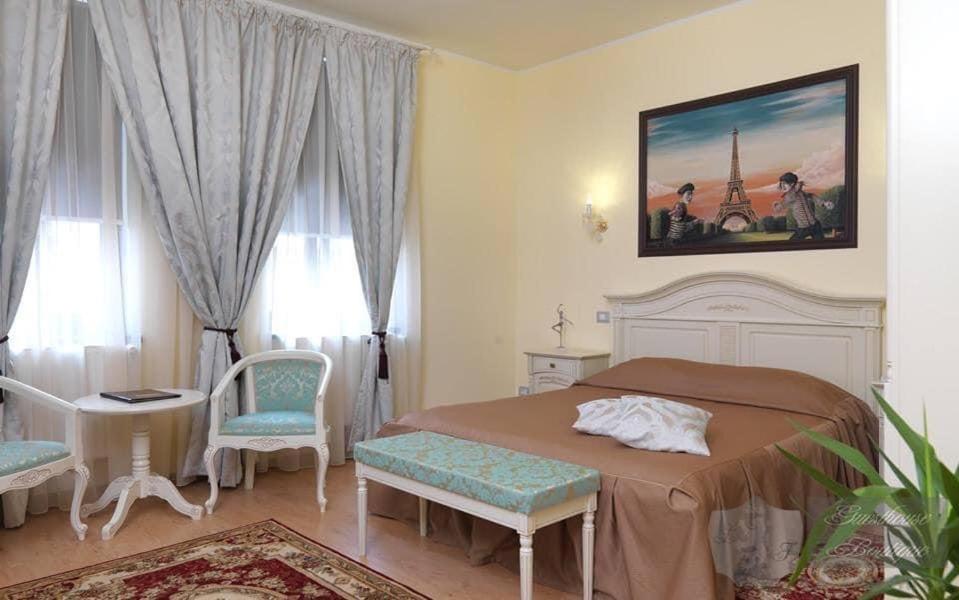 a bedroom with a bed and a table and chairs at La Favorita Guesthouse Boutique in Craiova