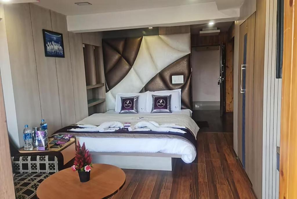a bedroom with a large bed with purple pillows at Goroomgo Broadway Mall Road Darjeeling - Best Hotel in Darjeeling in Darjeeling