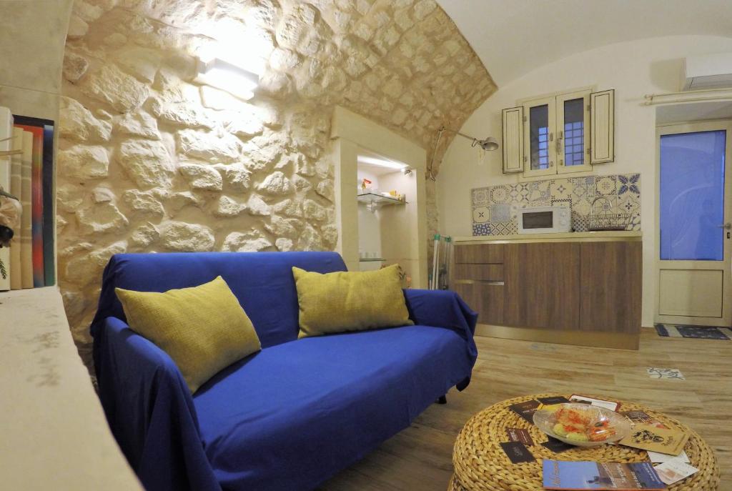salon z niebieską kanapą i stołem w obiekcie Al Borgo dell'Arte Suite w mieście Scicli