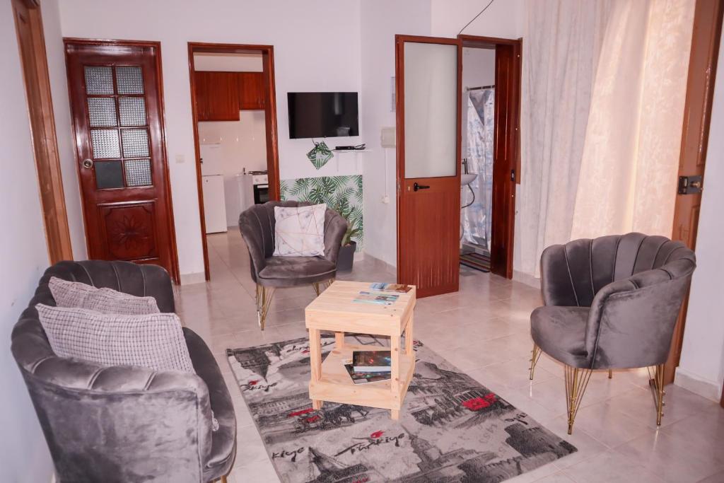 uma sala de estar com três cadeiras e uma mesa em Escape House em Tarrafal