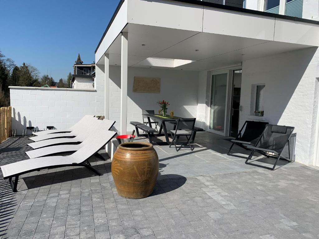 un patio con sillas y un jarrón grande en 5 bedrooms house with city view jacuzzi and enclosed garden at Spa en Spa