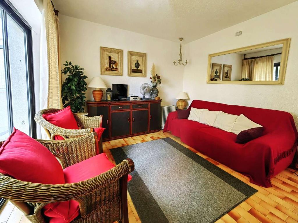 - un salon avec un canapé et des fauteuils rouges dans l'établissement T3 avec Terrasse, Piscine, Tennis et Parking Privé à 100m de la Plage - FR-1-607-1, au Cap d'Agde