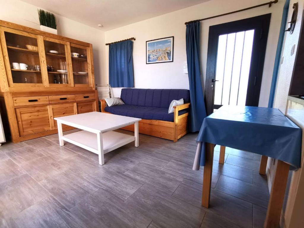 un salon avec un canapé bleu et une table dans l'établissement Appartement T2 avec Tennis, Piscine et Parking à 100m de la Mer - Cap d'Agde - FR-1-607-15, au Cap d'Agde