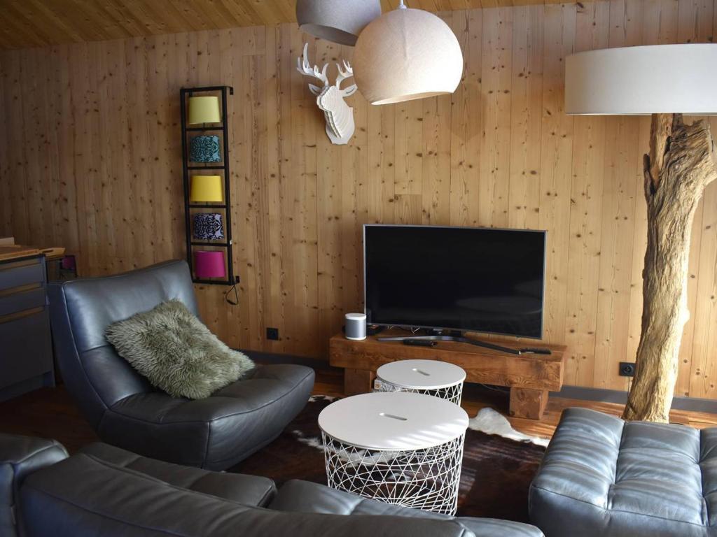 un salon avec un canapé et une télévision dans l'établissement Chalet individuel plein sud avec suites parentales, garage et équipements modernes – 8 pers. max - FR-1-580-111, à Font-Romeu-Odeillo-Via