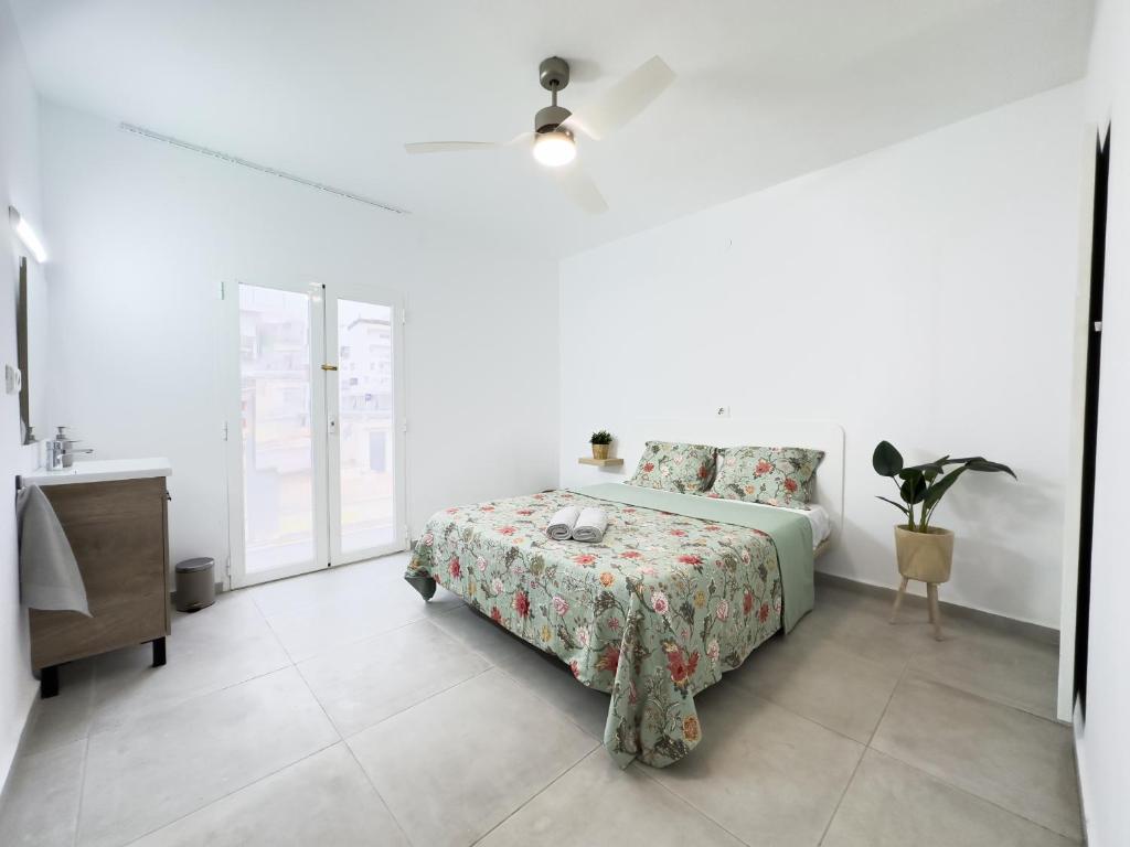 - une chambre blanche avec un lit, une table et un lavabo dans l'établissement Hostal Cisne, à Sant Antoni de Portmany