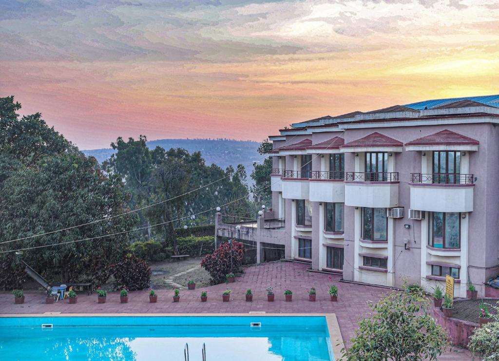 ein Gebäude mit einem Pool davor in der Unterkunft The Dhanhills - a valley view hotel in panchgani in Panchgani