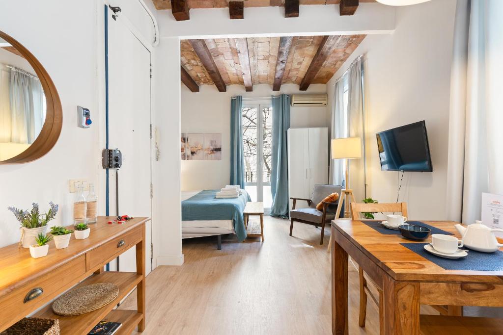 a living room with a dining table and a bedroom at Lodging Apartments Beach Studio P1 in Barcelona