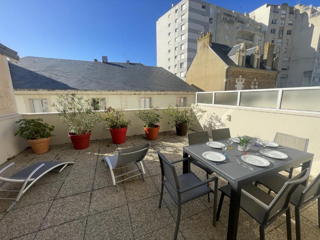 un patio avec une table et des chaises sur un balcon dans l'établissement LSO6096 L'Argonaute 50m de la Grande Plage, à Les Sables-dʼOlonne