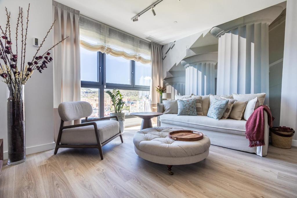 a living room with a white couch and a chair at Malaga Skyline 4 Pool & Parking Free in Málaga