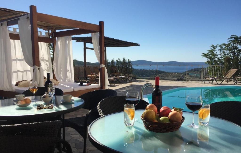 a table with glasses of wine and a basket of fruit at Villa Monica in Ložišće