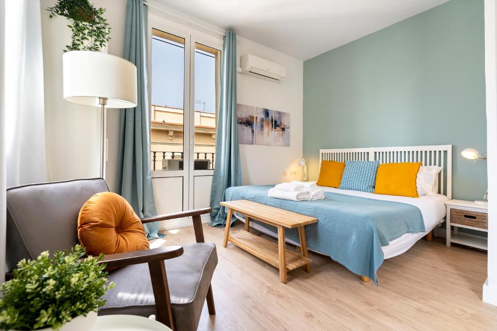 a bedroom with a bed and a couch and a table at Lodging Apartments Barceloneta Beach Studio 42 in Barcelona