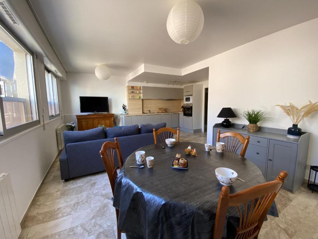 un salon avec une table et un canapé bleu dans l'établissement Appartement 2 etoiles proche plage, à Les Sables-dʼOlonne