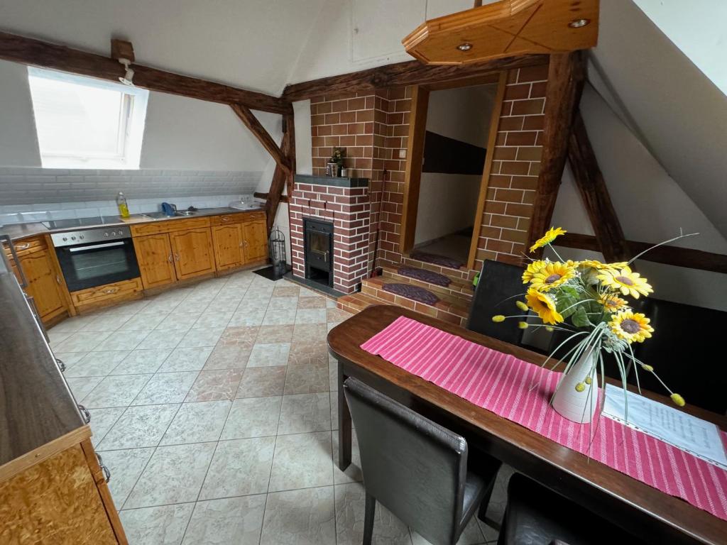 a kitchen with a table with a vase of flowers on it at Lausitzhof in Hoyerswerda