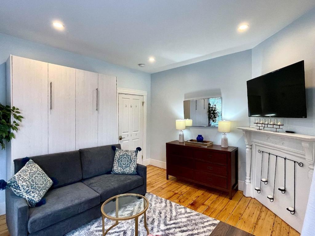 a living room with a couch and a flat screen tv at Renovated 4bed 15 Bath, Mit, Harvard,hospitals in Cambridge