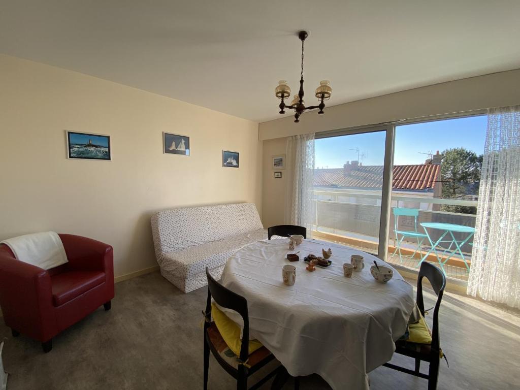- un salon avec une table, une chaise et un canapé dans l'établissement Appartement - PARKING - BALCON - Arago, à Les Sables-dʼOlonne