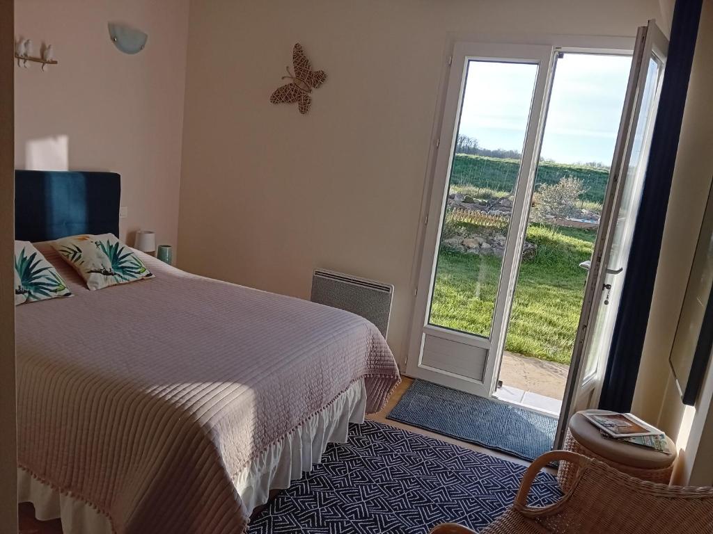 a bedroom with a bed and a large window at Cocooning au Saut du Loup in Lavergne