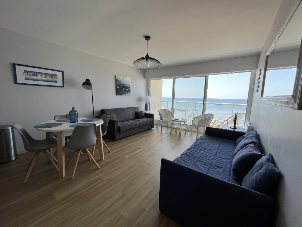 un salon avec un canapé et une table dans l'établissement Studio face mer - PARKING - Les Presidents, à Les Sables-dʼOlonne