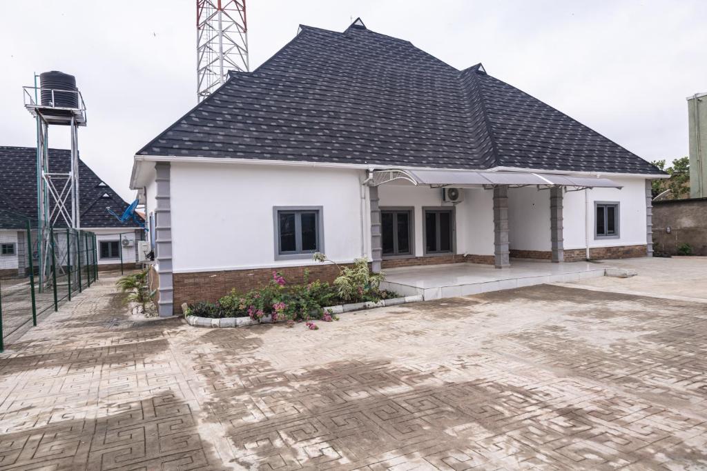 a white house with a black roof at VETTAS APARTMENT in Akure