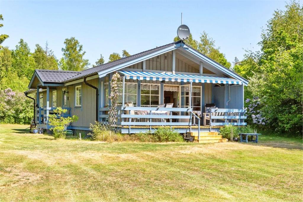 ein kleines grünes Haus mit einer großen Veranda in der Unterkunft Spacious villa with beautiful location outside Lottorp in Löttorp