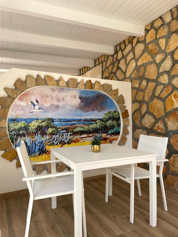 a white table and chairs in front of a stone wall at B&B SoleLuna in Lampedusa