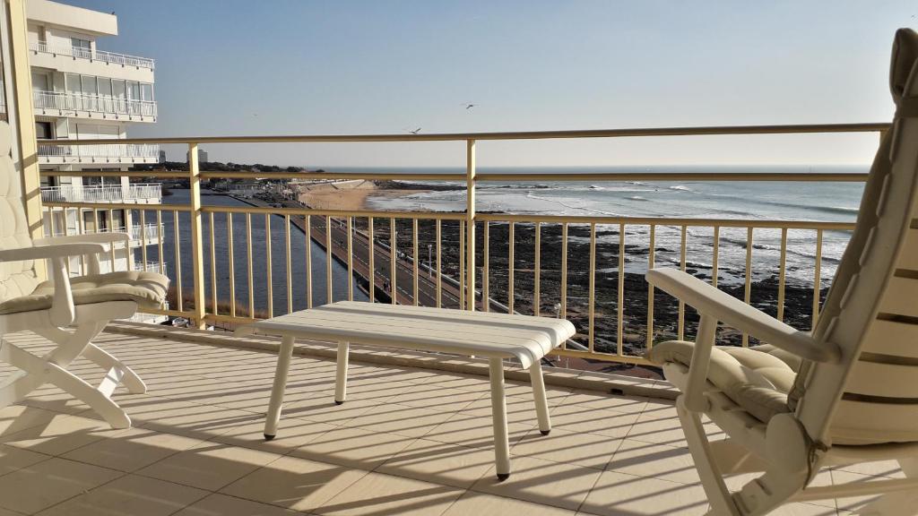 un balcon avec deux chaises et une vue sur l'océan dans l'établissement Appartement 2 étoiles face mer - 50m de la plage, à Les Sables-dʼOlonne