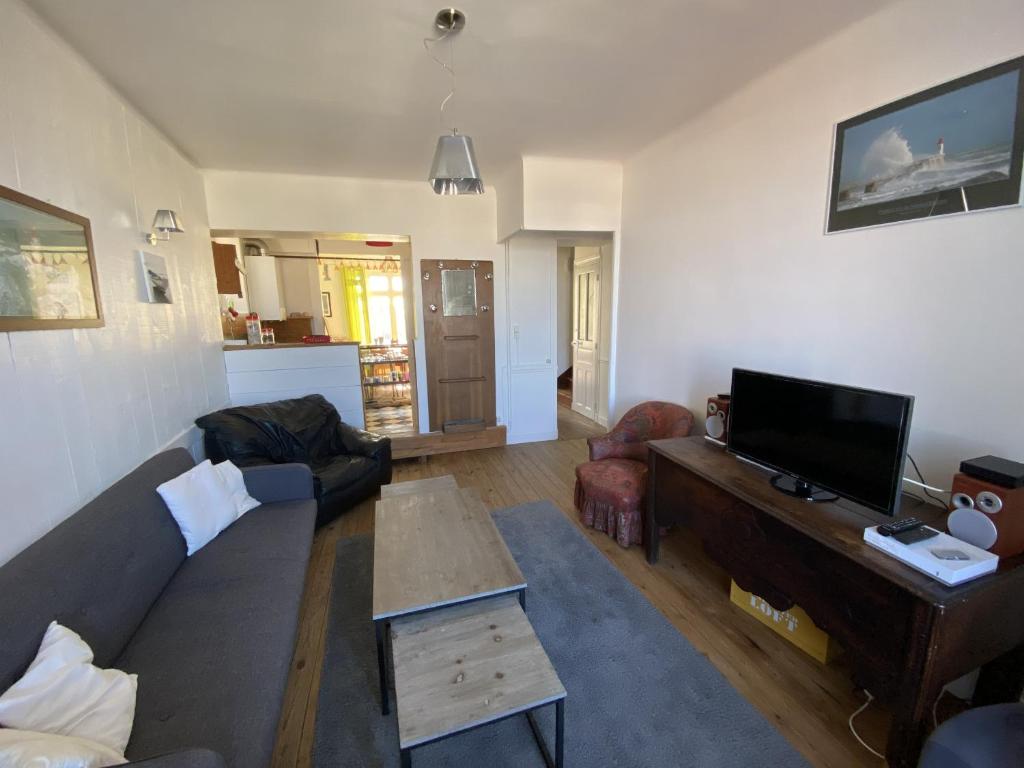 ein Wohnzimmer mit einem Sofa und einem TV in der Unterkunft Maison de ville 2 etoile proche plage in Les Sables-dʼOlonne