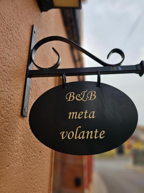 a black sign on the side of a building at META VOLANTE in Sagra