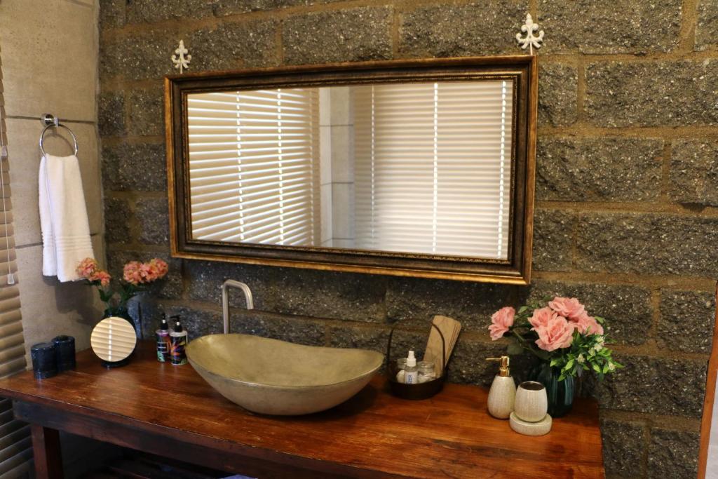 La salle de bains est pourvue d'un lavabo et d'un miroir. dans l'établissement Daisy Country Lodge, à Springbok