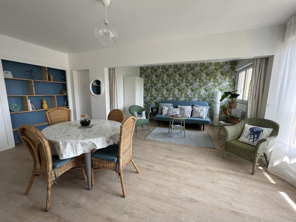 un salon avec une table, des chaises et un canapé dans l'établissement Le Pontereau 2 étoiles - PARKING - WIFI, à Les Sables-dʼOlonne