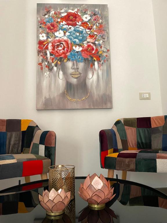 a room with two chairs and a painting on the wall at B&B SoleLuna in Lampedusa
