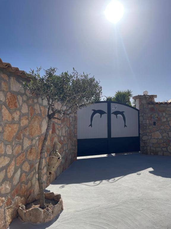 a gate with a tree in front of a stone wall at B&B SoleLuna in Lampedusa