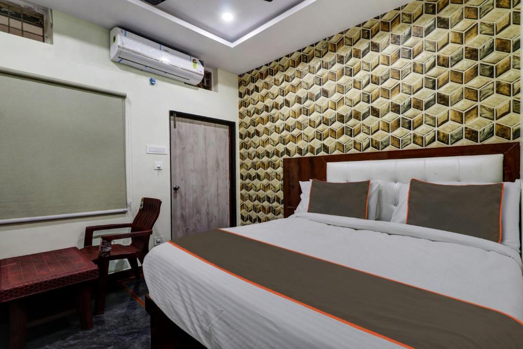 een slaapkamer met een bed, een stoel en een raam bij Collection O B SQUARE VILLA in Visakhapatnam