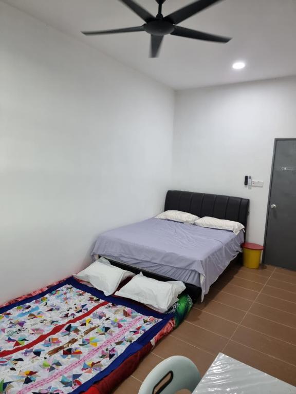 sypialnia z łóżkiem i wentylatorem sufitowym w obiekcie Happy Living w mieście Sibu