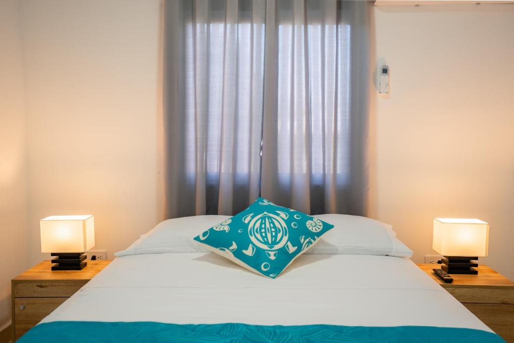 - un lit avec un oreiller bleu dans l'établissement Ketlina Village, à Île de la Providence