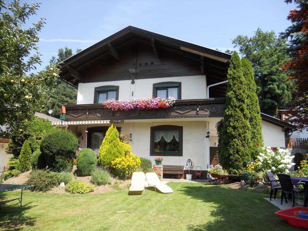 ein Haus mit einem Garten mit Stühlen und Blumen in der Unterkunft Ferienwohnung Gerti Kalt in Lieserhofen