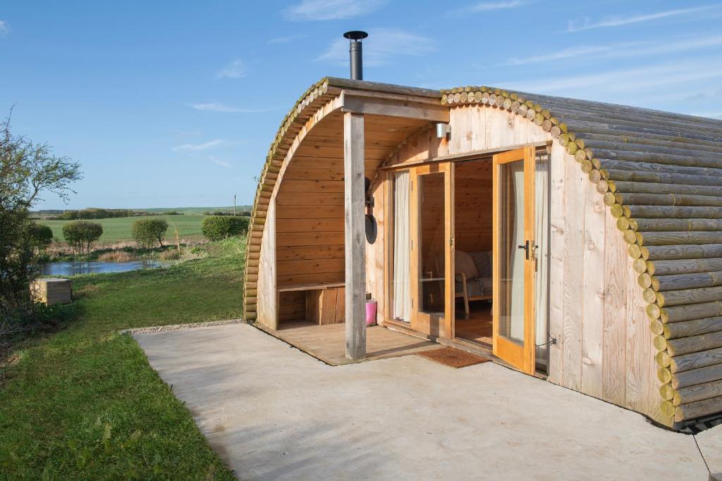 a small wooden house with a large open door at Glamping Pod 5 Shelter in Scarborough