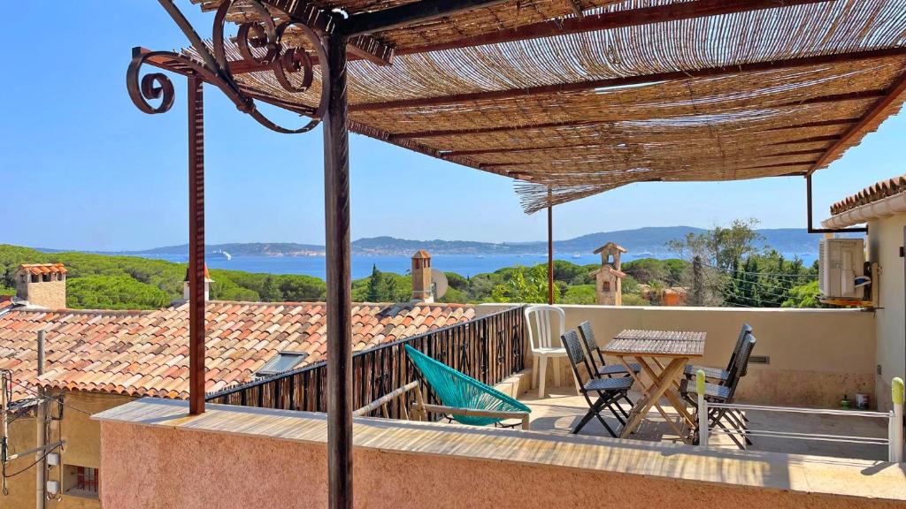 un patio avec une table et des chaises sur un balcon dans l'établissement Hameau de Guerrevieille, à Grimaud