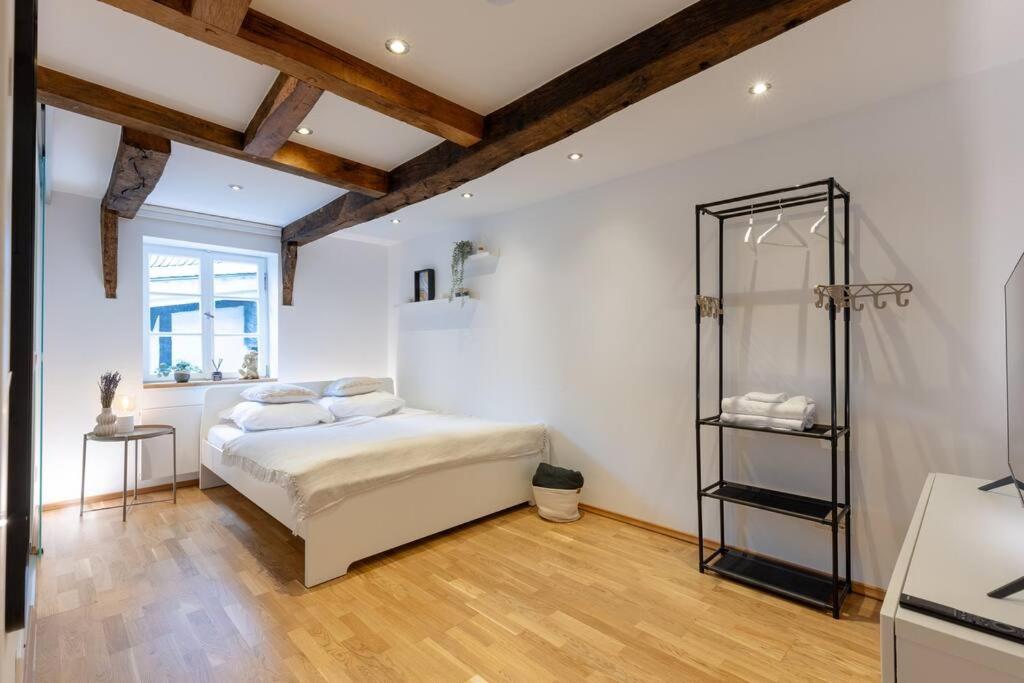 Schlafzimmer mit einem Bett mit weißen Wänden und Holzböden in der Unterkunft Fachwerk Boutique-Hotel 4 in Hattingen