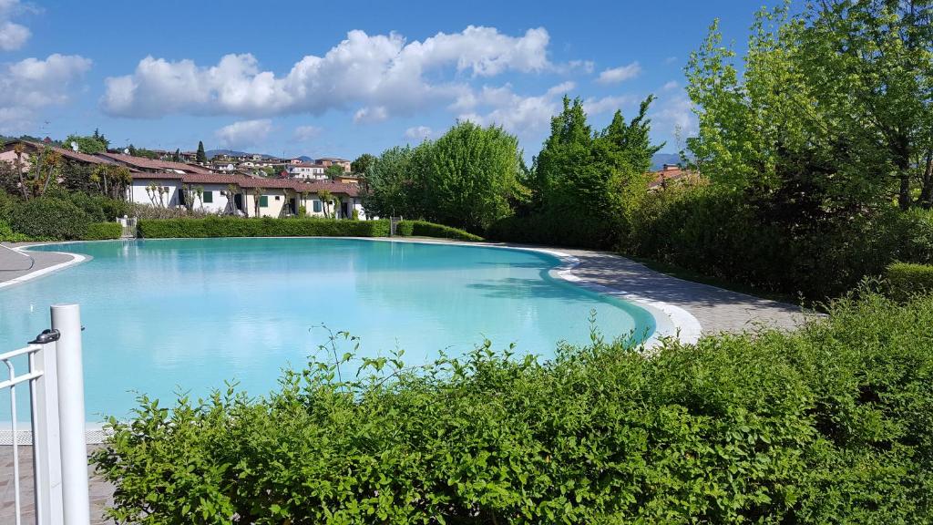uma grande piscina azul num quintal em Delizioso in Residence sul Garda em Polpenazze del Garda